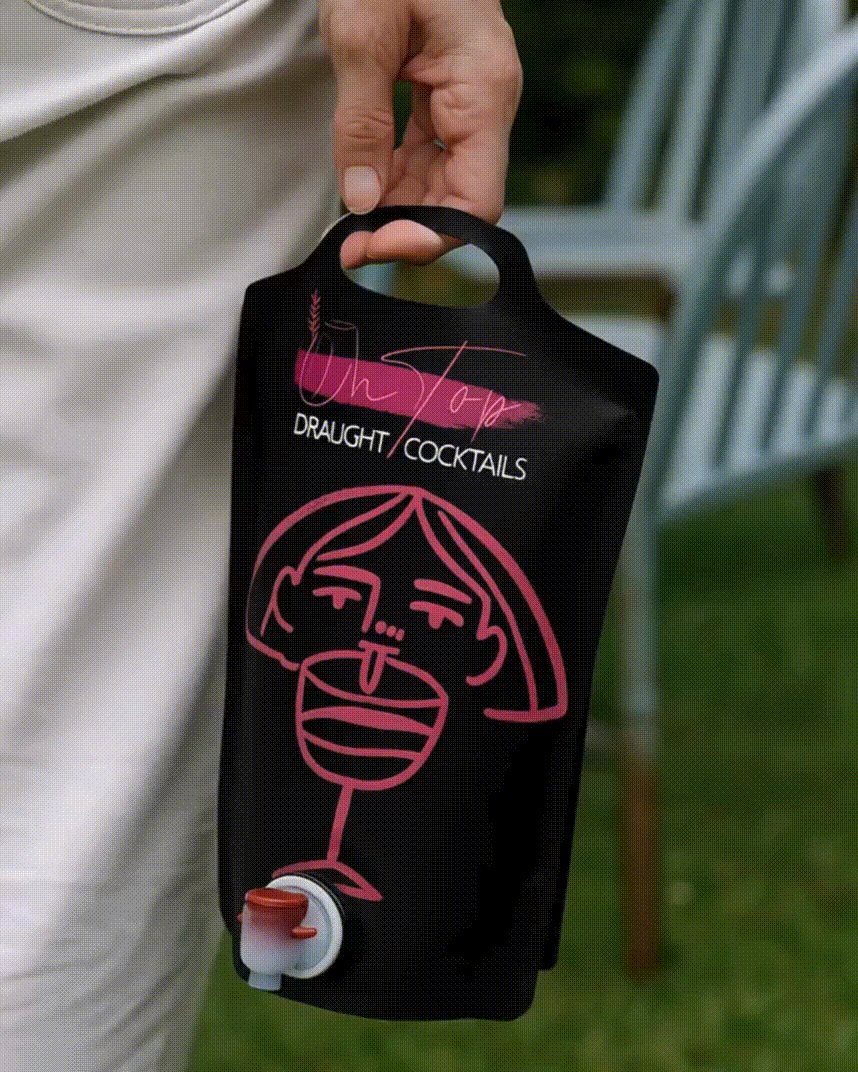 Rankose laikoma kokteilių statinė su pilamu kokteiliu į taurę.